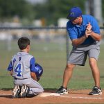 coach with child during baseball practice