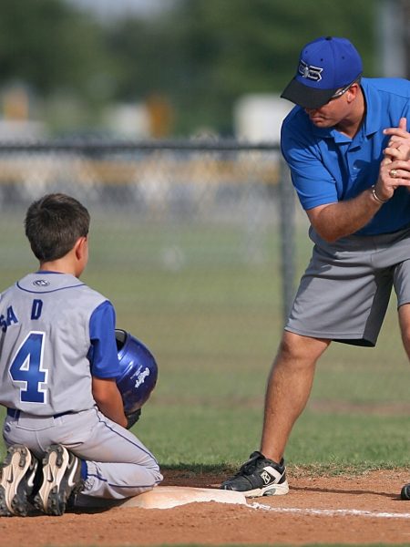 coach with child during baseball practice