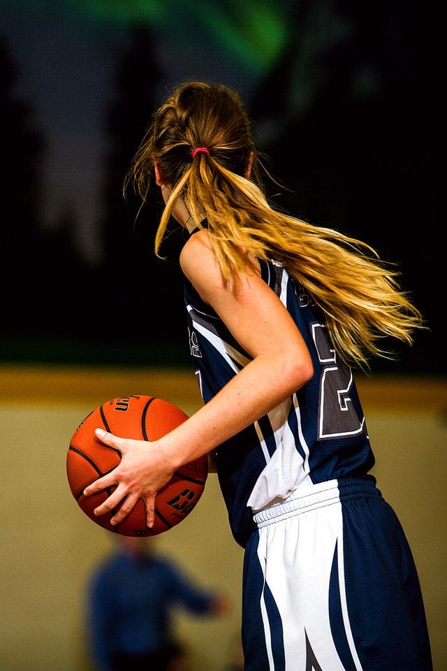 girl with baskeball in hands in middle school basketball game