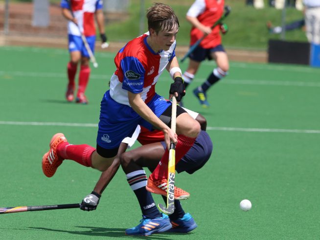 2 men playing field hockey at high school