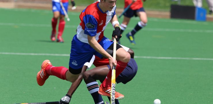 2 men playing field hockey at high school