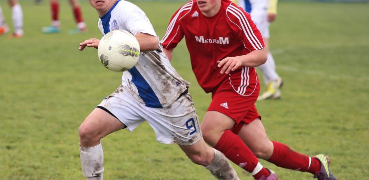 2 high school boys running playing soccer